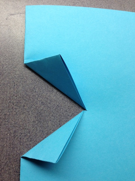 Fold up the corners of the cut edge as pictured. Score the new folded edges with a ruler. UNFOLD - flat again (not pictured)